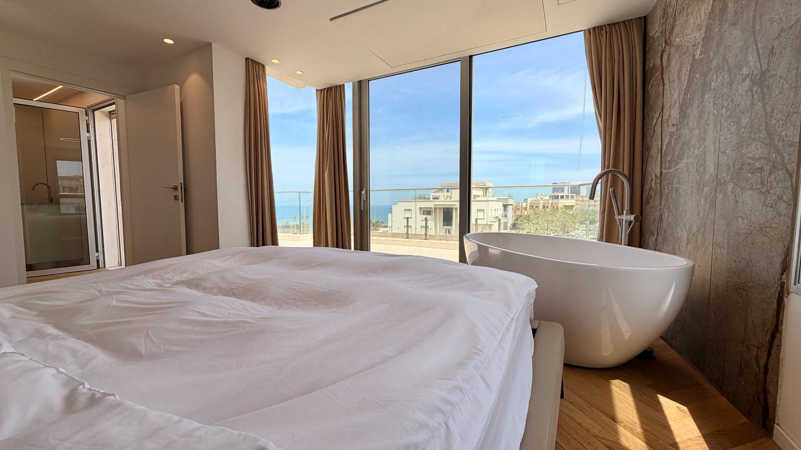 Suite parentale de la villa à Netanya, baignoire îlot face à la mer et grand balcon privé