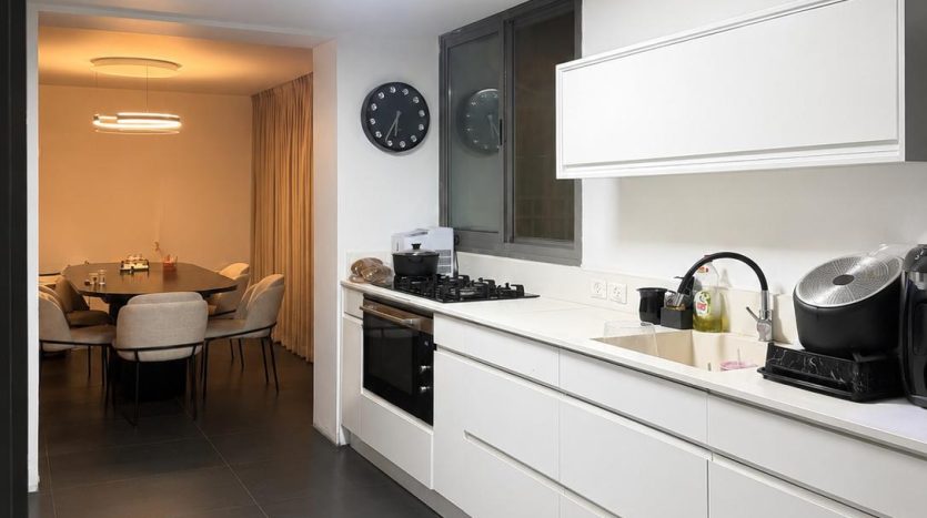 Cuisine blanche equipee ouverte sur la salle a manger, appartement a Har Homa, Jerusalem