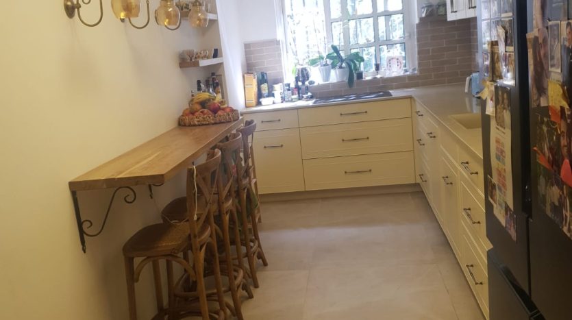 Cuisine equipee creme avec bar d un appartement renove a Jerusalem