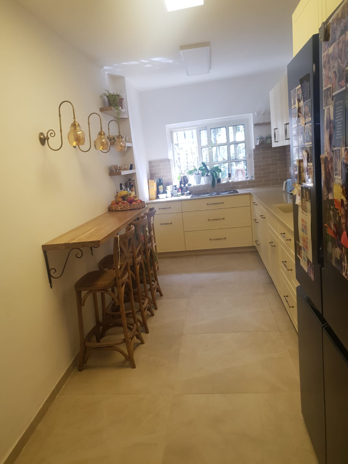 Cuisine équipée crème avec bar d'un appartement rénové à Jérusalem