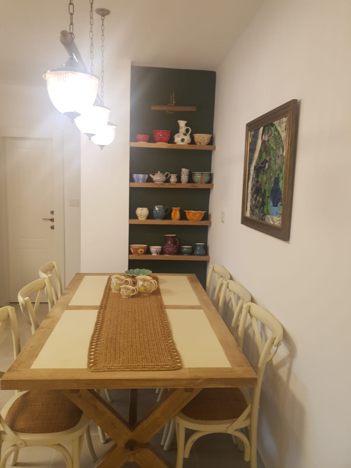 Salle à manger avec étagères et suspensions d'un appartement rénové à Jérusalem