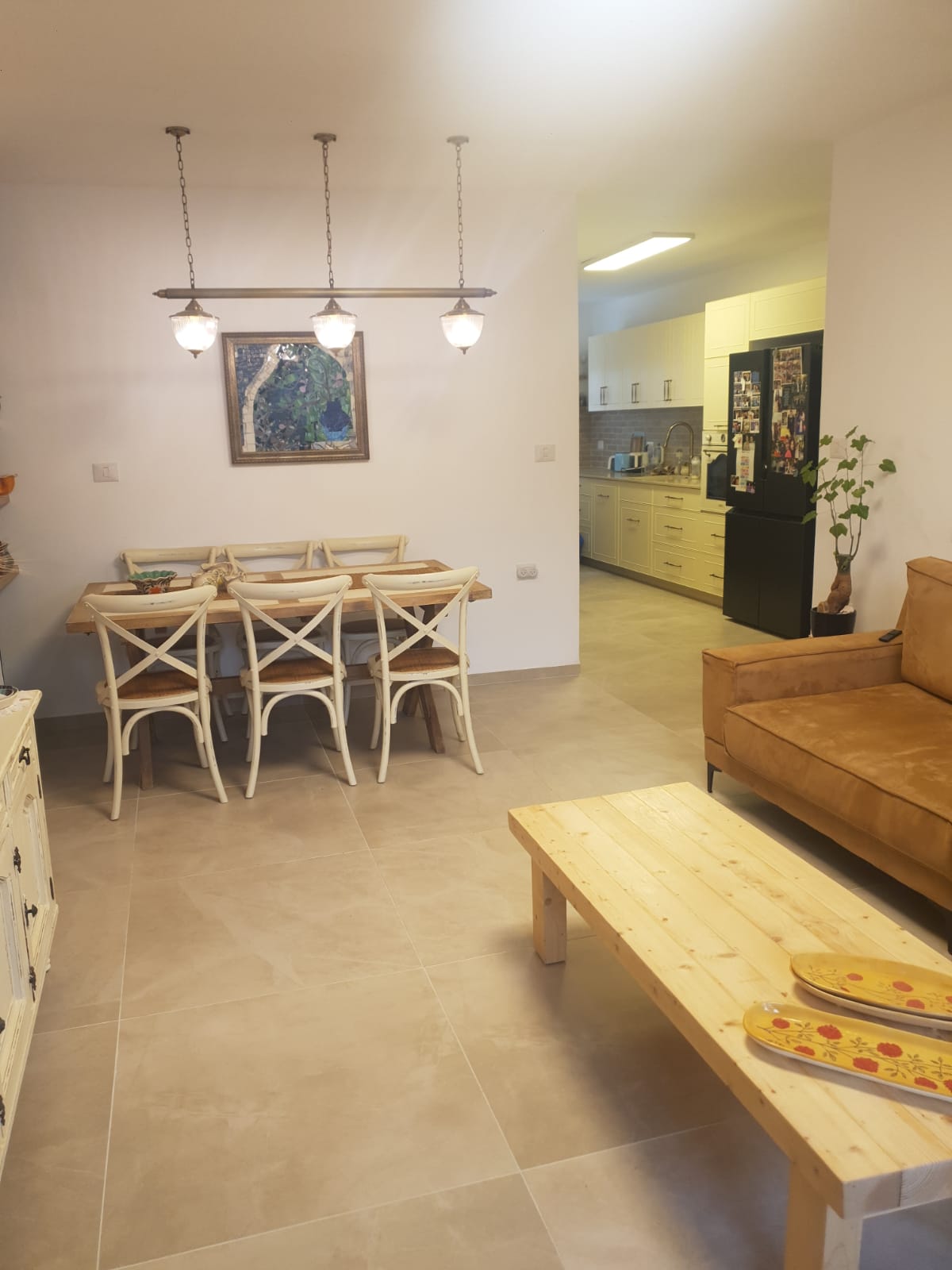 Séjour et salle à manger ouverts sur la cuisine d'un appartement 3 pièces rénové à Jérusalem