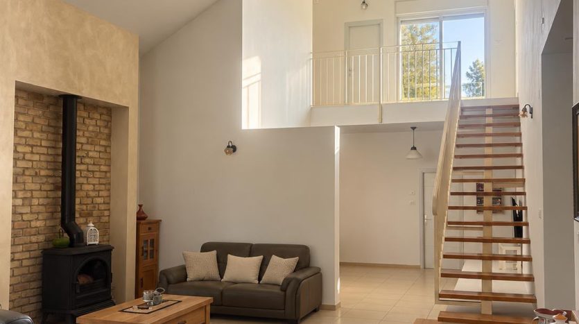 Grand salon a double hauteur avec mezzanine et cheminee d une villa a Ben Ami